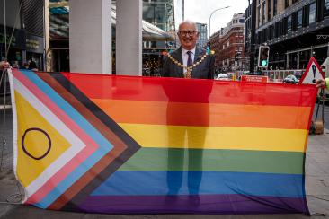 The Lord Mayor, Cllr Paul Dimoldenberg stands behind the pride flag before raising it outside City Hall