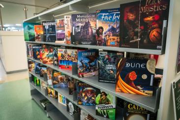 A series of board games lined up on shelves.