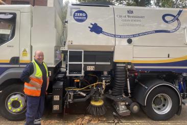 A member of Veolia street cleansing team in front of a new electric gully truck