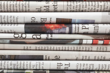 Colour photo of stack of English newspapers 