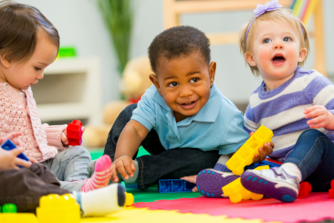 three babies playing with Duplo