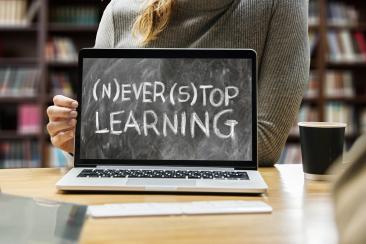 A laptop screen reading 'never stop learning'