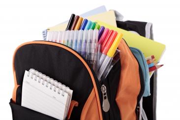 Colour photo of backpack full of notebooks, felt tips pens, pencils etc