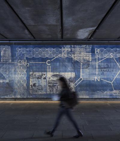 Image of a person walking in a tunnel with a blue background