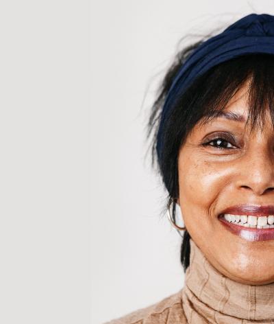 Image of a woman smiling on plain gray background