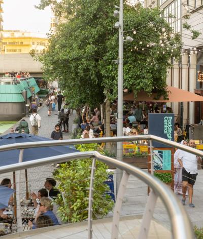 An area of the canalside near Paddington with restaurants and people walking 