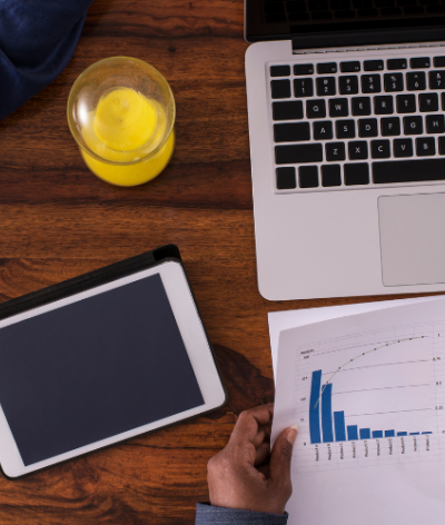 Two people sitting at a table with a laptop and business papers