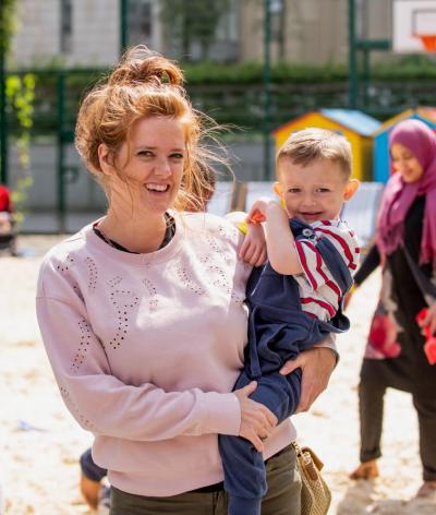 Woman carring a baby at a playground