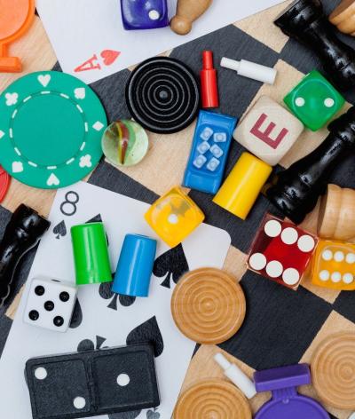 an image of random games pieces such as dice, chess board and cards. 