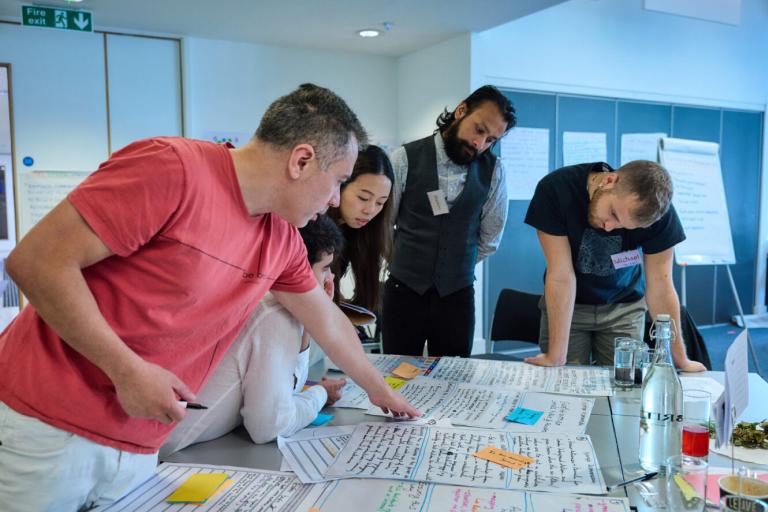 Image of four people looking a paper on a table