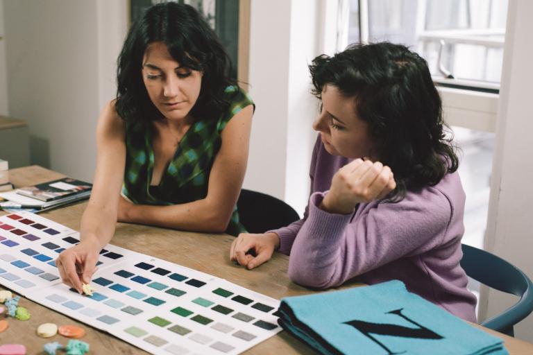 two members of the team from hades looking at fabric colours