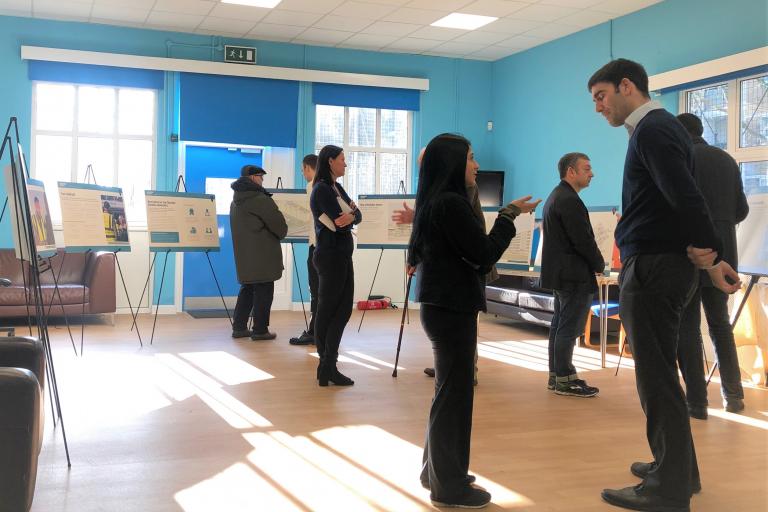 People standing and having a discussion during consultation boards presentation.jpg