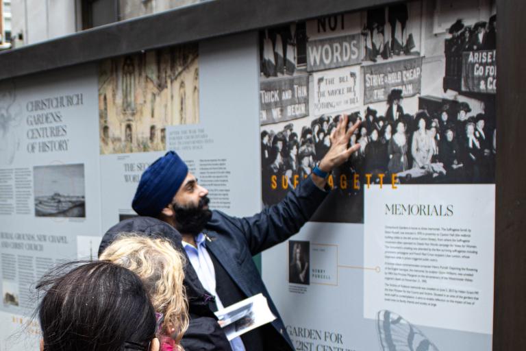 A tour guide explaining a sign on the sikhopoly tour