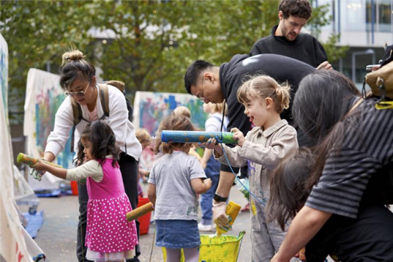 a group of children and parents painting on canvasses