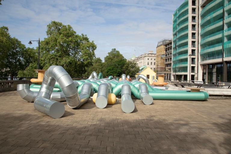 Lots of large green and silver metal tubes on the roof of temple tube station