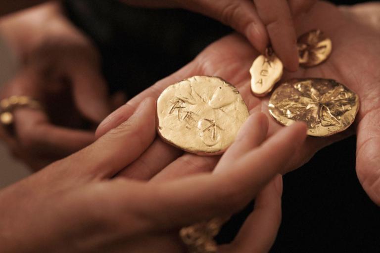 Image of two hands holding gold homemade jewellery