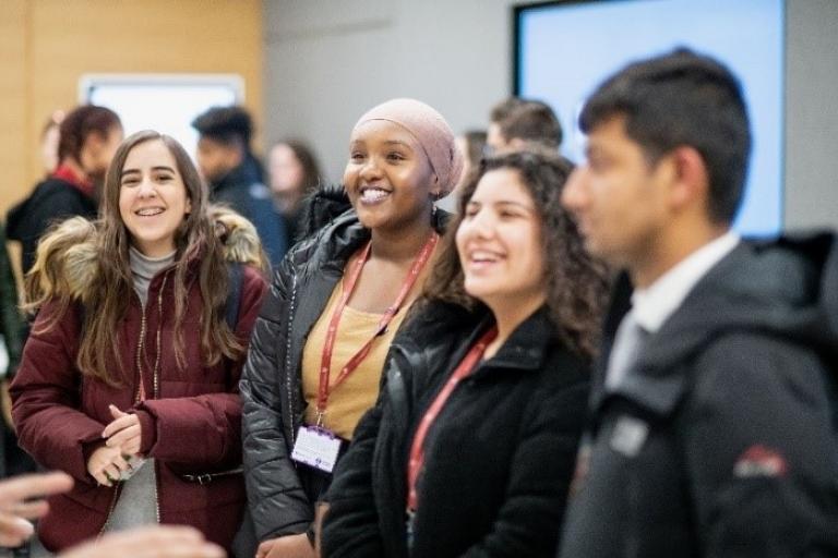 A group of smiling young people looking at someone off camera