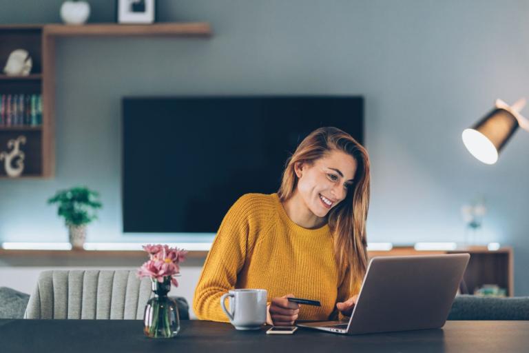 Woman using bankcard whilst on a laptop