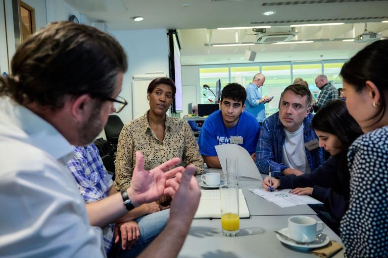 A group of people talking around a table 