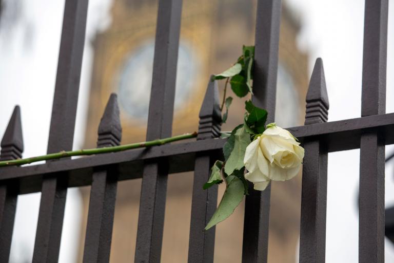 A white rose hangs from the gates of the Palace of Westminster in front of Big Ben in the aftermath of the Westminster Bridge attacks in March 2017