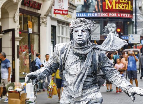 image of a man, painted silver and acting as a human statue 