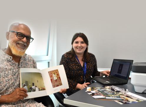 Image of an elderly man and a woman helping him with digitising his photos